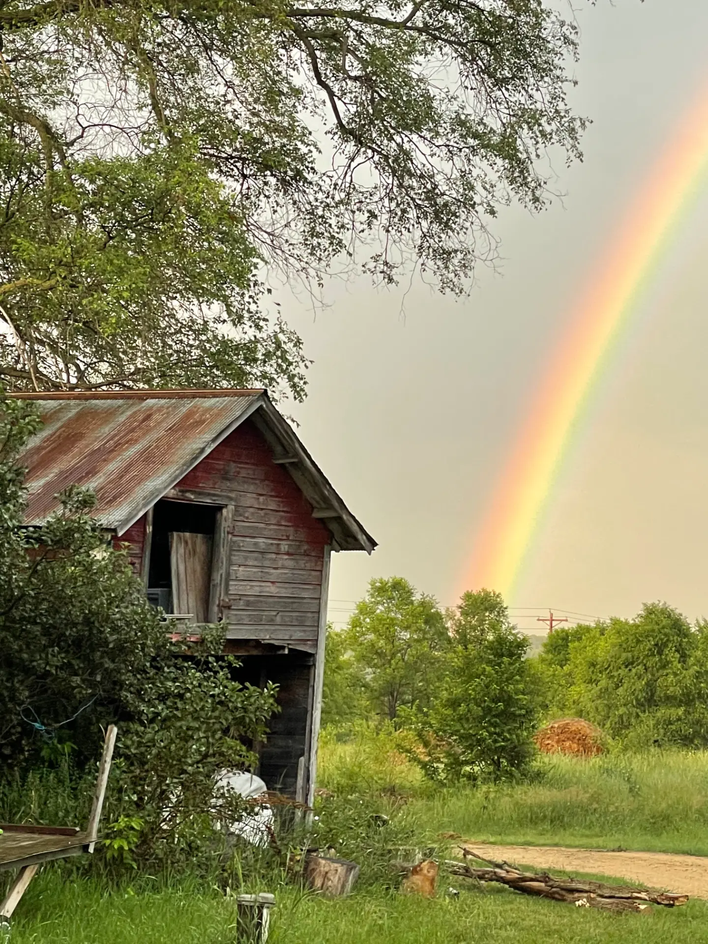 Rainbow over the old red barn at the farm